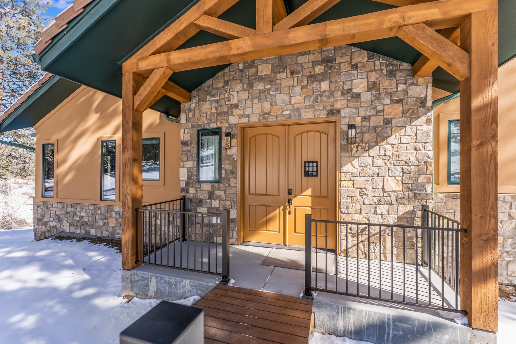 Timber-and-stone mountain home entrance finished by JEI Painting